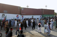 Supporters of ousted Pakistani Prime Minister Imran Khan try to remove shipping containers placed by authorities to block way for an anti government rally, in Islamabad, Pakistan, Thursday, May 26, 2022. Defiant former Prime Minister Khan early Thursday warned Pakistan's government to set new elections in the next six days or he will again march on the capital along with 3 million people. (AP Photo/Anjum Naveed)