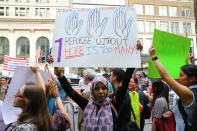 <p>Magila of the Brooklyn, who moved to the U.S. four years ago, holds up a placard at the start of a protest and march outside the New York Public Library on 42nd Street in New York City on June 20, 2018. (Photo: Gordon Donovan/Yahoo News) </p>