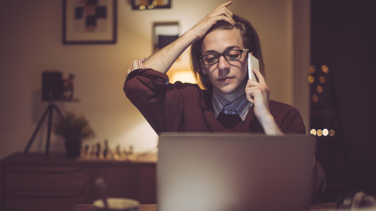 Young man is working late on his laptop at home.