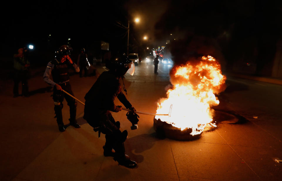 <p>Polizeibeamte entfernen während der Proteste gegen den honduranischen Präsidenten Juan Orlando Hernández in Tegucigalpa, Honduras, eine brennende Barrikade. Hernández siegte im vergangenen Monat trotz sehr strittiger Abstimmungsergebnisse. Die Opposition plant, auch nach seiner Vereidigung am 27. Januar, weiterhin gegen das Wahlergebnis zu protestieren. (Bild: AP Photo) </p>