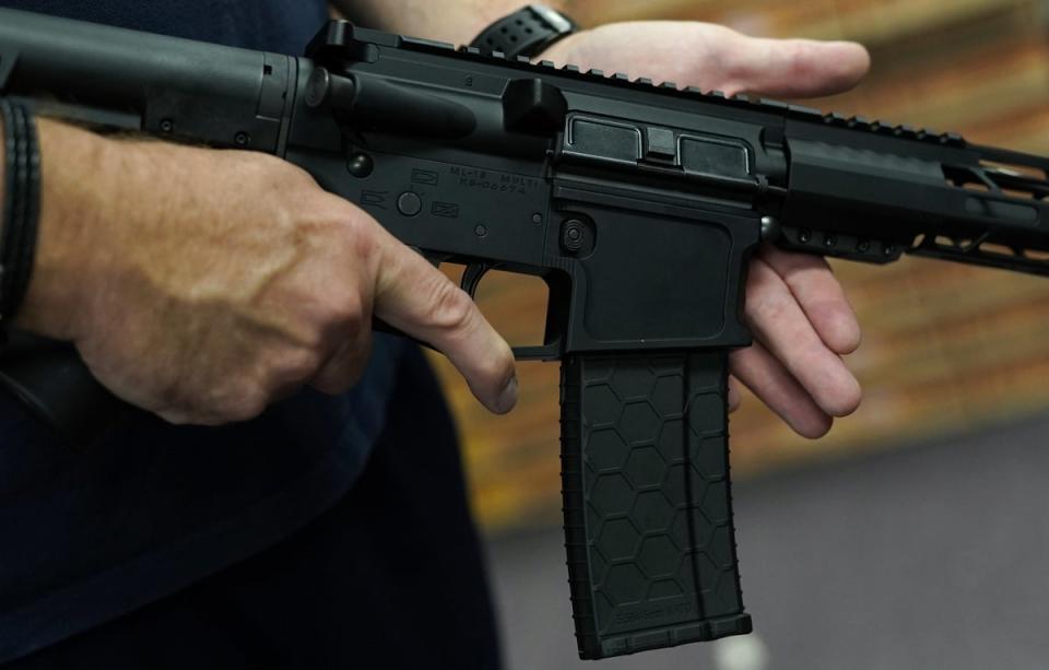 Un cliente muestra un rifle AR-15 en una tienda en Nueva York (Timothy A Clary/AFP vía Getty Images)