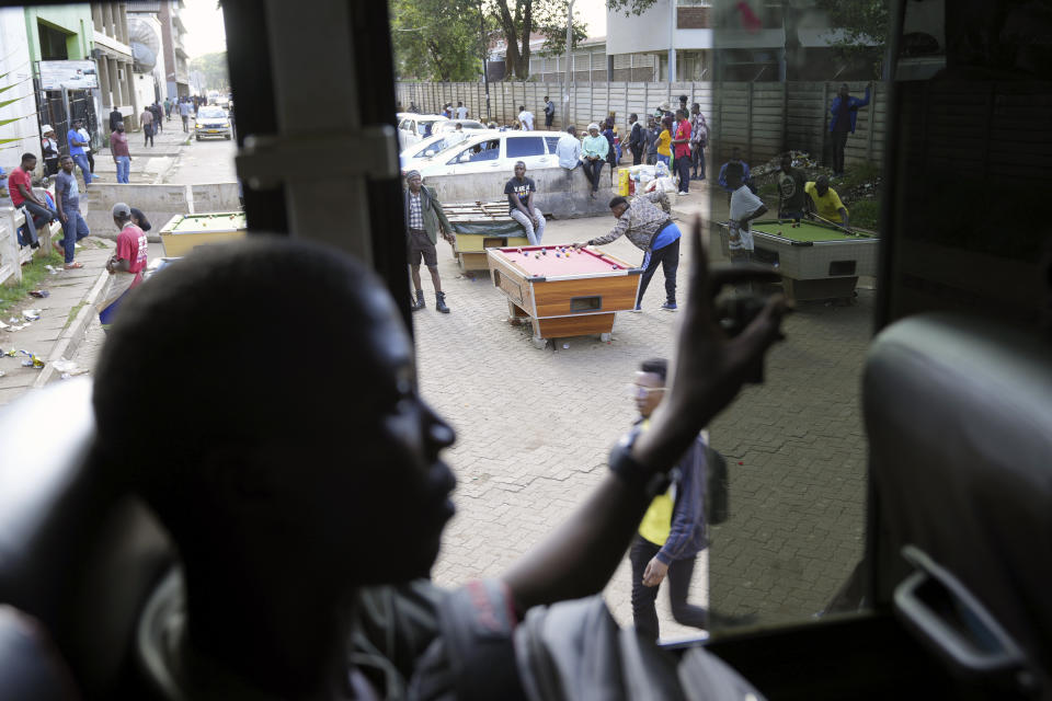 People play pool in an open space in Harare, Zimbabwe, Wednesday, Nov. 30, 2022. Previously a minority and elite sport in Zimbabwe, the game has increased in popularity over the years, first as a pastime and now as a survival mode for many in a country where employment is hard to come by. (AP Photo/Tsvangirayi Mukwazhi)