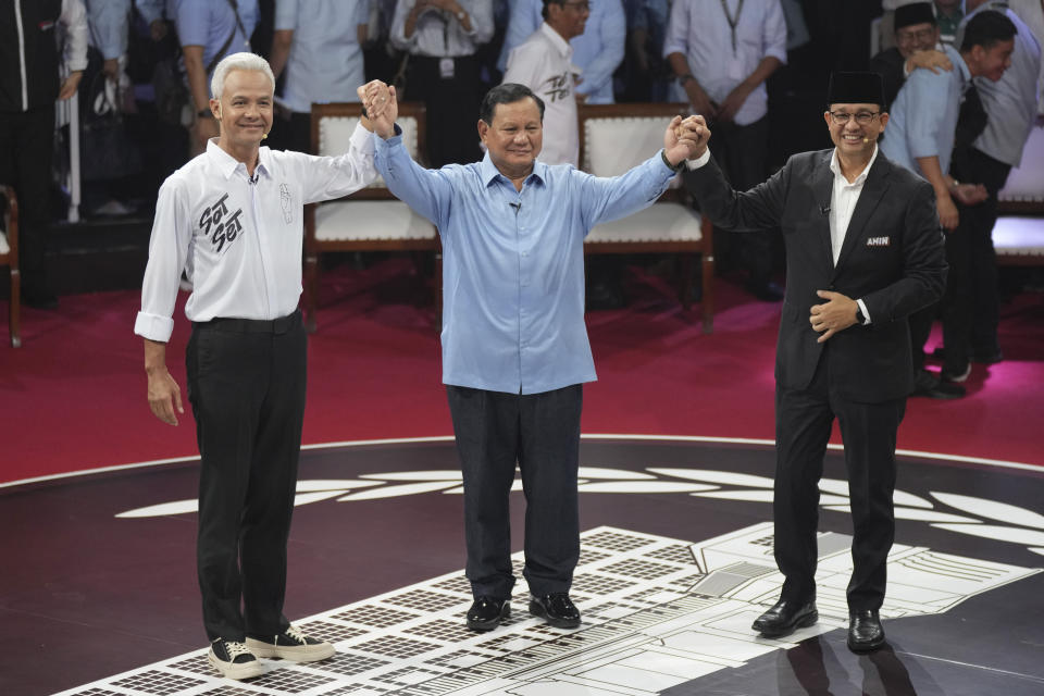 FILE - Indonesia's Presidential candidates, from left, Ganjar Pranowo, Prabowo Subianto and Anies Baswedan gesture as they pose for photographers after the first presidential candidates' debate, in Jakarta, Indonesia, Tuesday, Dec. 12, 2023. Indonesians on Wednesday, Feb. 14, 2024 will elect the successor to popular President Joko Widodo, who is serving his second and final term. It is a three-way race for the presidency among current Defense Minister Prabowo Subianto and two former governors, Anies Baswedan and Ganjar Pranowo. (AP Photo/Tatan Syuflana, File)