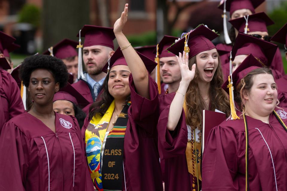 Members of the Class of 2024 at Dean College wave to family members and friends during commencement exercises Saturday on the campus, May 18, 2024.