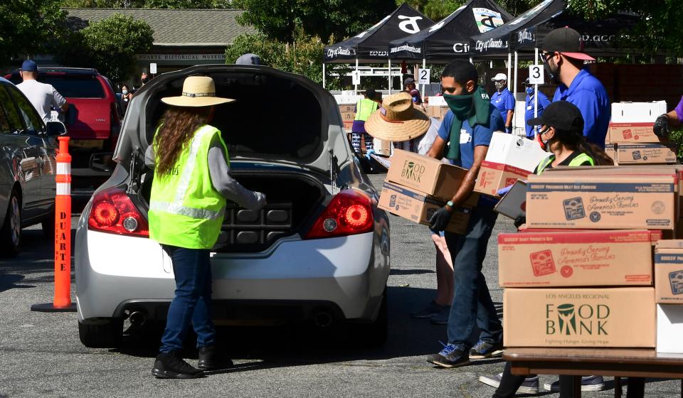 Volunteers help load a vehicle with boxes of food at a food bank in the Los Angeles County city of Duarte, California on July 8, 2020 as the record for most coronavirus cases in a single day is set in California. - Oxfam, the confederation of 19 charitable independent organizations focusing on the alleviation of global poverty, is due to release an embargoed report on July 9 suggesting that COVID-19 may kill more people worldwide due to hunger than the illness itself. (Photo by Frederic J. BROWN / AFP) (Photo by FREDERIC J. BROWN/AFP via Getty Images)