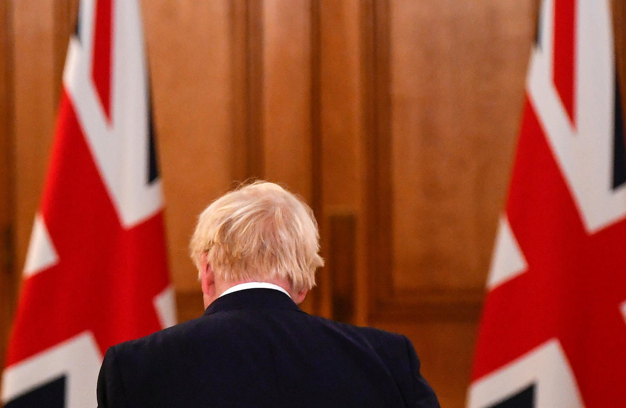 Britain's Prime Minister Boris Johnson passes Union flags as he leaves following a virtual press conference inside 10 Downing Street in central London on October 12, 2020, after announcing a new COVID-19 alert system. - British Prime Minister Boris Johnson on Monday ordered pubs in Liverpool to shut as part of a new strategy to tackle a surge in coronavirus cases, as staff at three field hospitals across the country were told to prepare for a wave of admissions. The northwest English city is the first to be placed at "very high risk" under a new three-tiered system designed to bring order what has become a complex web of local restrictions. (Photo by TOBY MELVILLE / POOL / AFP) (Photo by TOBY MELVILLE/POOL/AFP via Getty Images)