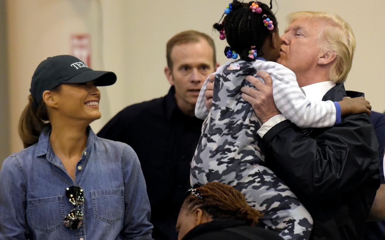 Donald Trump with a young survivor of Hurricane Harvey - AP