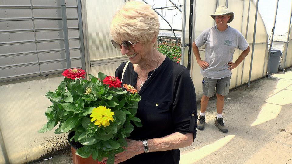 Ocean County Commissioner Virginia E. Haines is presented zinnias by MidAtlantic Growers' Ron Harrison during a stop there in New Egypt Friday, July 15, 2022.  This stop and others in Plumsted Township, were part of the 25th anniversary of voters approving the Natural Lands Trust Program in the county.