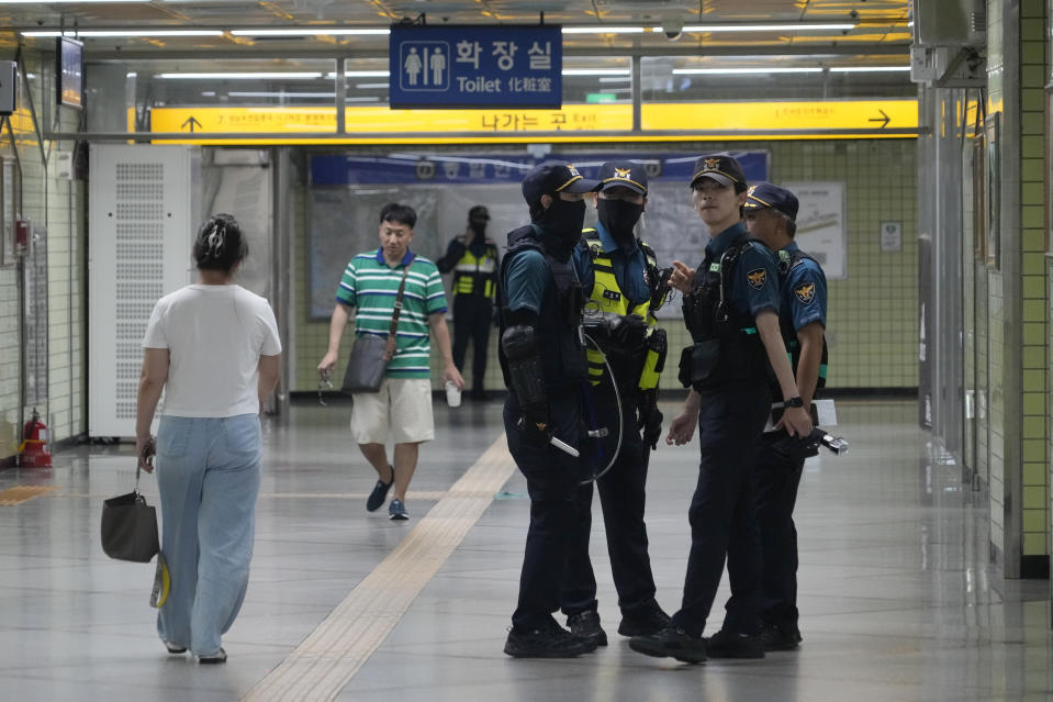 Police officers stand guard at Ori subway station following Thursday's attack in Seongnam, South Korea, Friday, Aug. 4, 2023. South Korean police detained a man suspected of stabbing a high school teacher with a knife Friday in the city of Daejeon. The stabbing follows a separate, apparently random attack on Thursday in which 14 people were wounded near a busy subway station in Seongnam. (AP Photo/Ahn Young-joon)