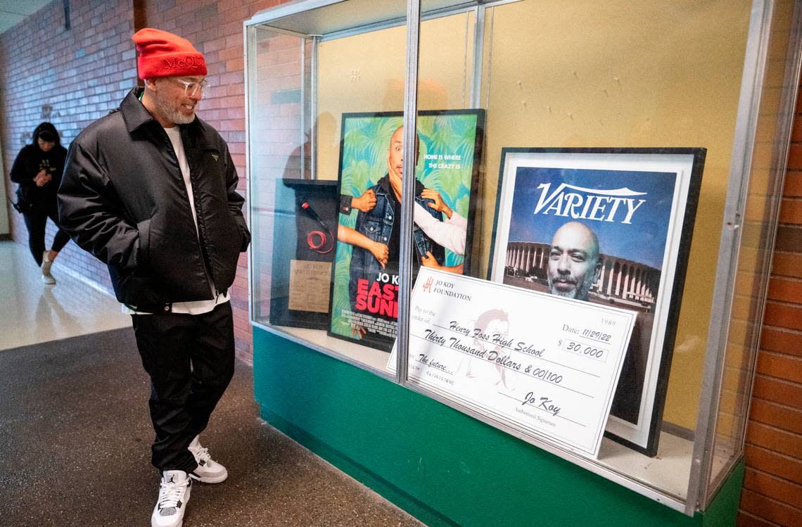 Comedian Jo Koy admires the framed poster from his movie “Easter Sunday”, a framed cover of Variety magazine and a microphone that he donated to his alma mater, Foss High School, along with a check for $30,000 to the Foss Scholarship Fund that will be dedicated to Foss students going into the arts.