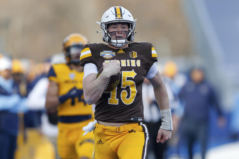 Wyoming quarterback Levi Williams (15) runs down the sidelines on a 50 yard touchdown run against Kent State during the first half of the Idaho Potato Bowl NCAA college football game, Tuesday, Dec. 21, 2021, in Boise, Idaho. (AP Photo/Steve Conner)