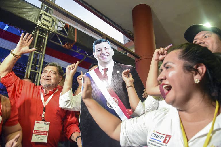 Partidarios del candidato presidencial paraguayo por el Partido Colorado, Santiago Peña, celebran después de conocer los primeros resultados de las elecciones generales y presidenciales en Asunción el 30 de abril de 2023