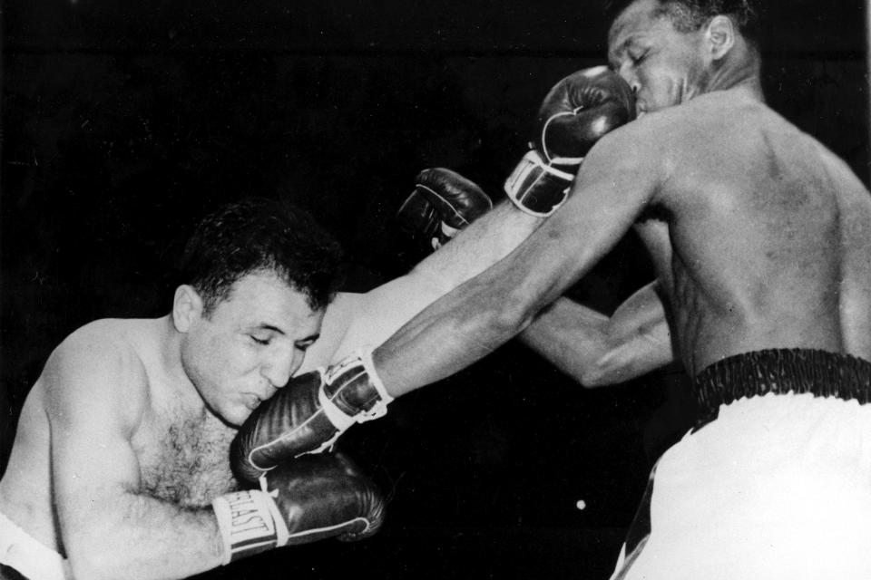 FILE - In this Feb. 14, 1951, file photo, Jake LaMotta, left, and Sugar Ray Robinson exchange lefts to the face in the first round of their middleweight championship bout at Chicago Stadium in Chicago, Ill. Jake LaMotta was a straight up brawler, so determined to wreak havoc every time he entered the boxing ring that he handed the great Sugar Ray Robinson his first loss. He was pretty much the same outside the ring, which is why Hollywood made a movie about his life. "Raging Bull" was No. 7 in The Associated Press’ Top 25 favorite sports movies poll. (AP Photo/File)