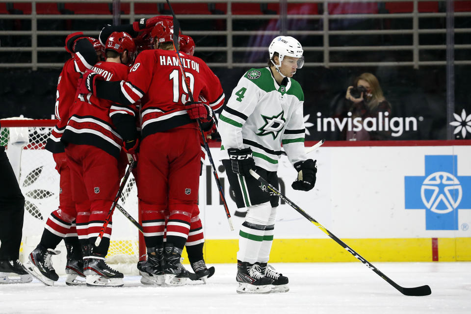 Carolina Hurricanes players celebrate a goal by Jordan Staal as Dallas Stars' Miro Heiskanen (4) skates past during the first period of an NHL hockey game in Raleigh, N.C., Sunday, Jan. 31, 2021. (AP Photo/Karl B DeBlaker)