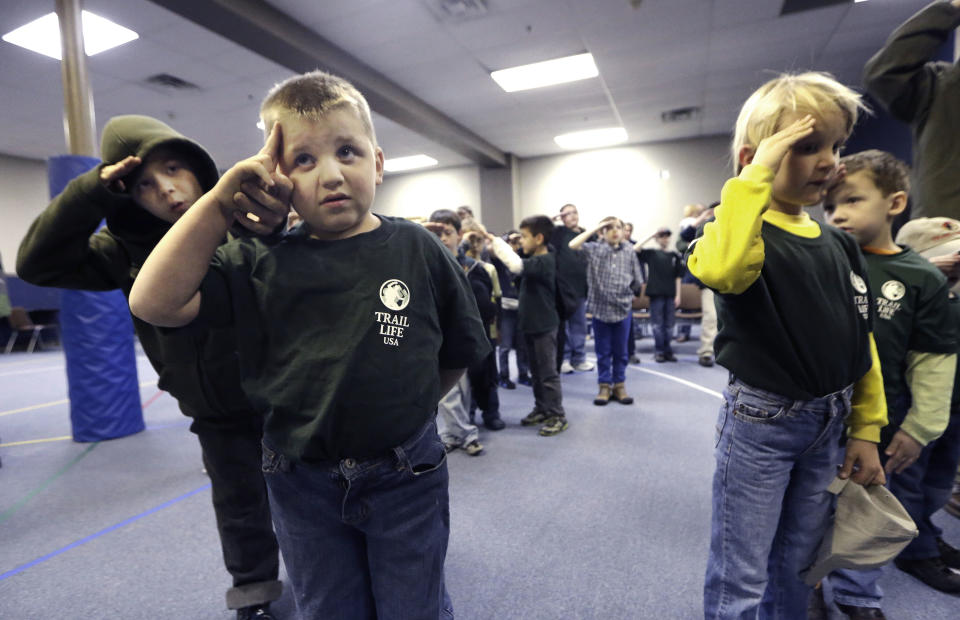 In this Tuesday, Feb. 4, 2014 photo, Trail Life member Adrian McCade, 7, second from left, gets direction on hand placement for the salute from his older brother Jack McCade, 8, during a group meeting in North Richland Hills, Texas. John Stemberger, an Orlando, Fla. lawyer who led the opposition to the Boy Scouts of America's May 2013 vote to accept openly gay youth, went on to found Trail Life. (AP Photo/LM Otero)