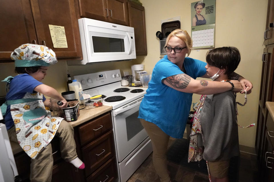 In this July 28, 2021 photo, Christina Darling and her sons, Brennan, 4, left, and Kayden, 10, prepare a snack at home in Nashua, N.H. Darling and her family have qualified for the expanded child tax credit, part of President Joe Biden's $1.9 trillion coronavirus relief package. "Every step closer we get to a livable wage is beneficial. That is money that gets turned around and spent on the betterment of my kids and myself," said Darling, a housing resource coordinator who had been supplementing her $35,000-a-year salary with monthly visits to the Nashua Soup Kitchen and Shelter's food pantry. (AP Photo/Elise Amendola)