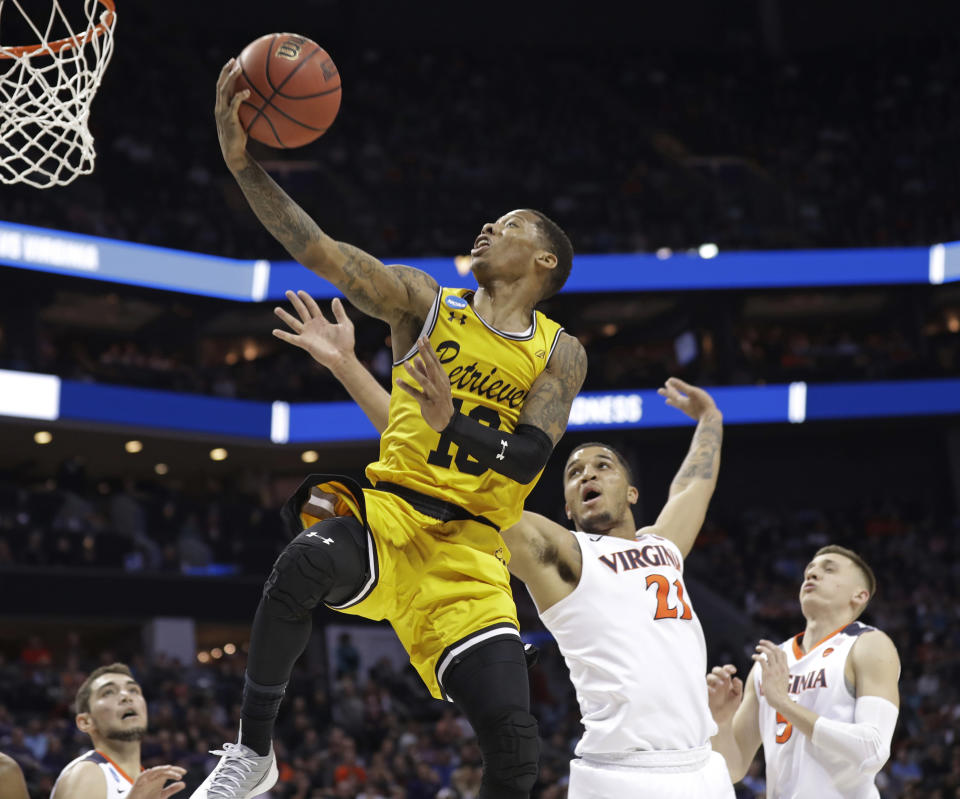 UMBC’s Jairus Lyles (10) drives past Virginia’s Isaiah Wilkins (21) and Kyle Guy (5) during the second half of a first-round game in the NCAA men’s college basketball tournament in Charlotte, N.C., Friday, March 16, 2018. (AP Photo/Gerry Broome)