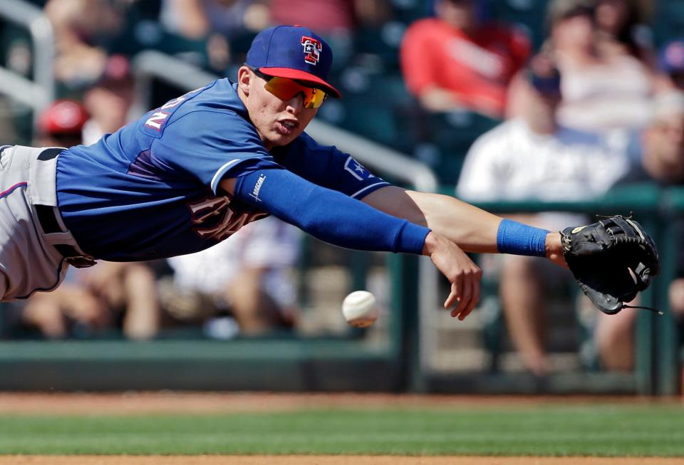 Drew Robinson, then with the Texas Rangers, dives for a ball in a 2013 spring training game.