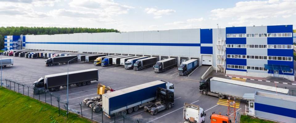 An e-commerce logistics warehouse with semi trucks outside