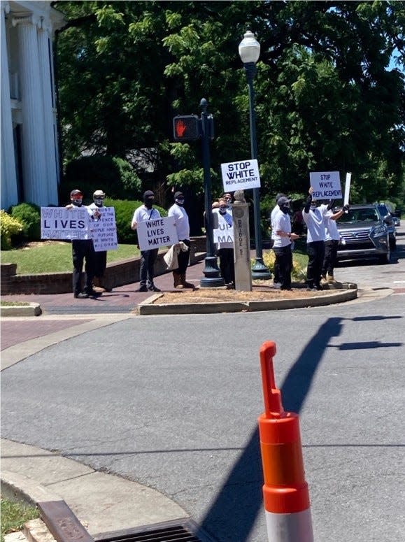 Masked protesters carrying signs demonstrating against "white replacement" attended the Juneteenth celebration in Franklin, Tennessee on June 19, 2022.