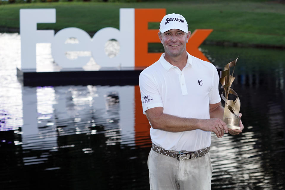 Lucas Glover holds the winner's trophy after winning the St. Jude Championship golf tournament Sunday, Aug. 13, 2023, in Memphis, Tenn. (AP Photo/George Walker IV)