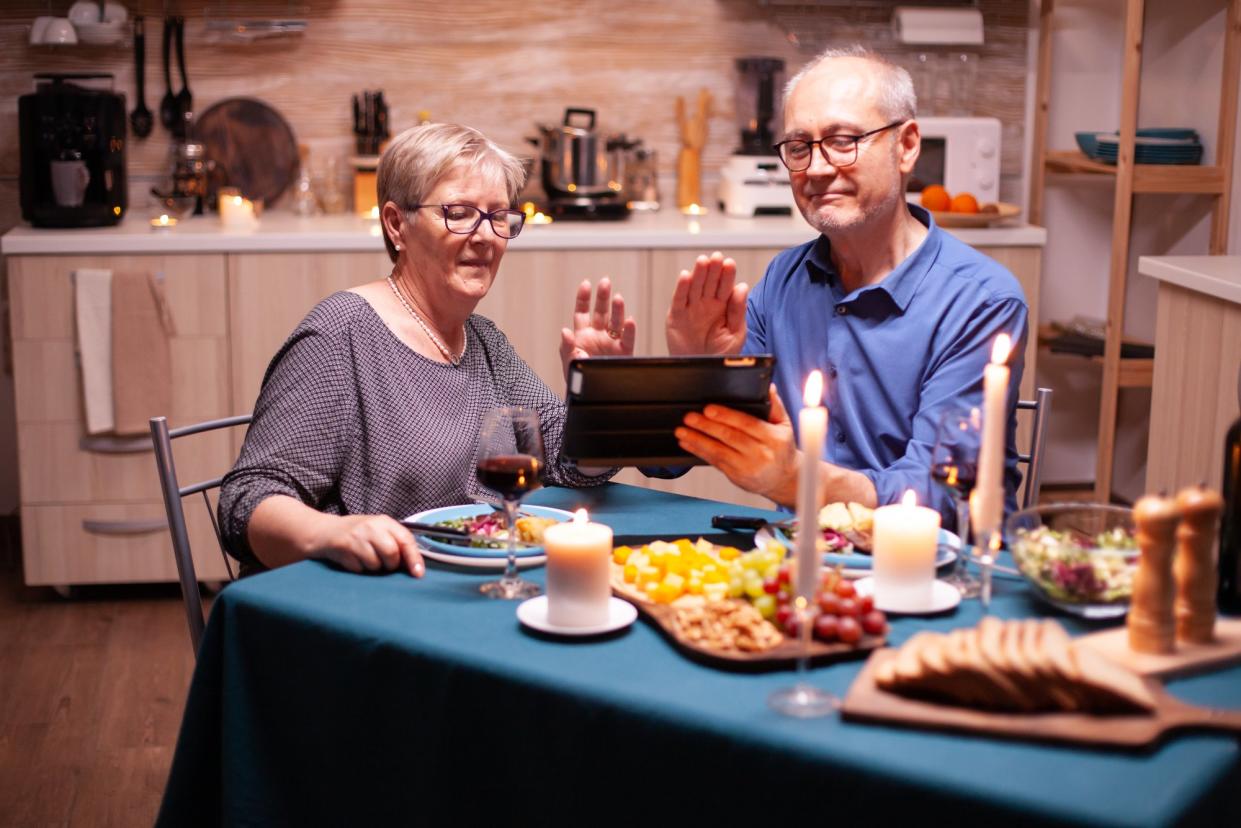 Couple enjoys a nice Christmas dinner while staying virtually connected to their loved ones. 