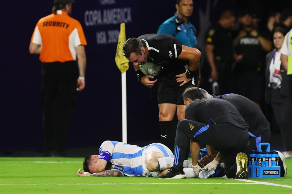 Argentina forward Lionel Messi reacts as trainers check his injury on Sunday.