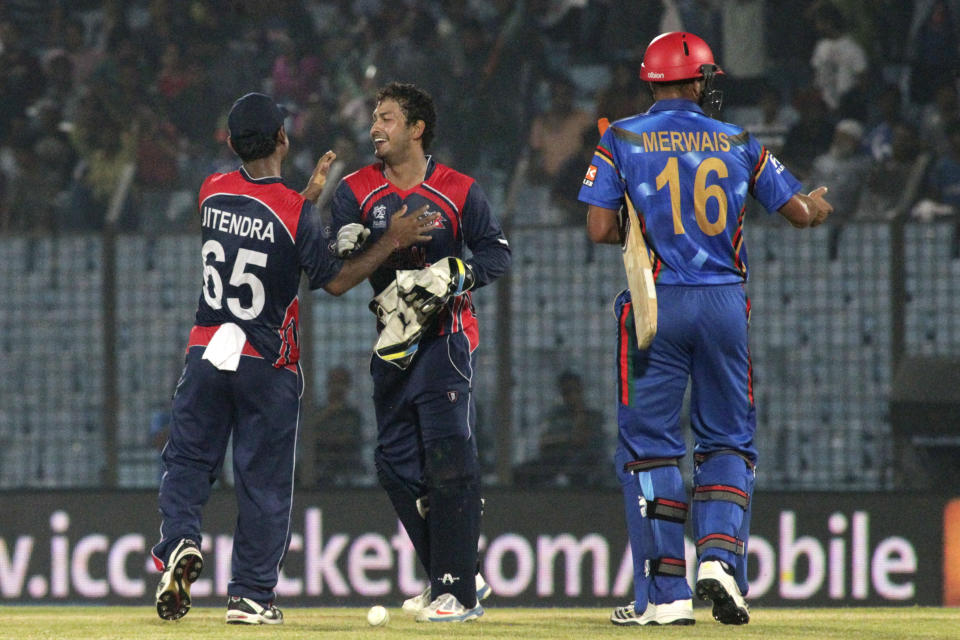 Nepal's Subash Khakurel, second right, and Jitendra Mukhiya celebrate after defeating Afghanistan by nine runs during their ICC Twenty20 Cricket World Cup match in Chittagong, Bangladesh, Thursday, March 20, 2014. Afghanistan's Mirwais Ashraf at right. (AP Photo/Bikas Das)