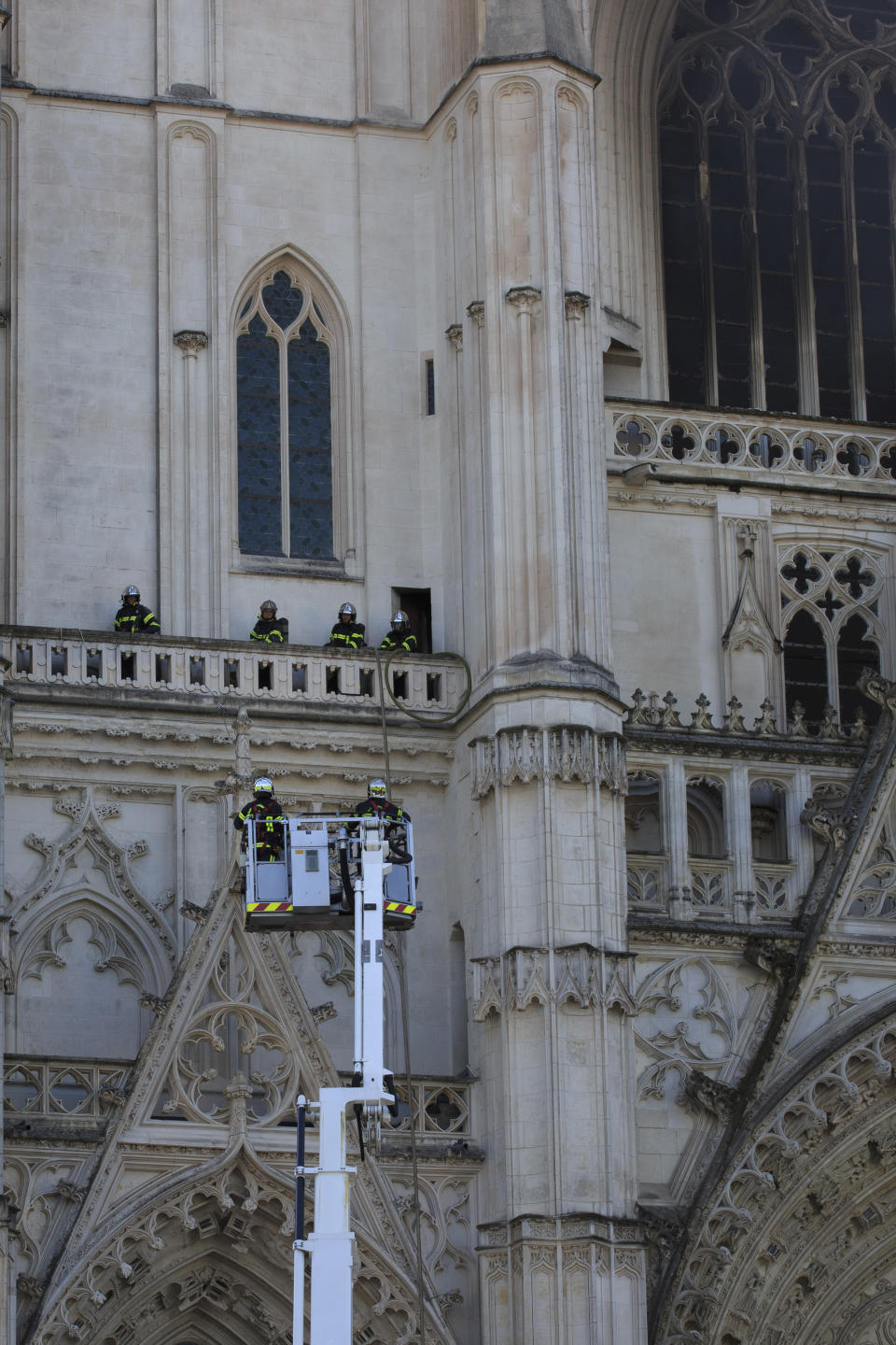 Fire fighters brigade work to extinguish the blaze at the Gothic St. Peter and St. Paul Cathedral, in Nantes, western France, Saturday, July 18, 2020. The fire broke, shattering stained glass windows and sending black smoke spewing from between its two towers of the 15th century, which also suffered a serious fire in 1972. The fire is bringing back memories of the devastating blaze in Notre Dame Cathedral in Paris last year that destroyed its roof and collapsed its spire and threatened to topple the medieval monument. (AP Photo/Laetitia Notarianni)