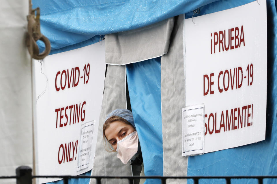 A medical worker sticks her head outside a COVID-19 testing tent set up outside Elmhurst Hospital Center in New York, Saturday, March 28, 2020. The hospital is caring for a high number of coronavirus patients in the city, and New York leads the nation in the number of cases, according to Johns Hopkins University, which is keeping a running tally. (AP Photo/Kathy Willens)