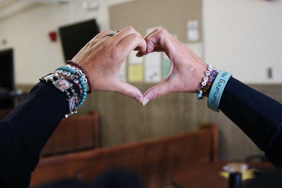 Scarlett Lewis, mother of 6-year-old Sandy Hook shooting victim Jesse Lewis, shows her jewelry that reads, "nurturing, healing love," after jurors returned a punitive damages verdict of $45.2 million against Alex Jones on Friday. Her son Jesse had written those words on a chalkboard before he died. She now uses the phrase as part of her Choose Love movement.