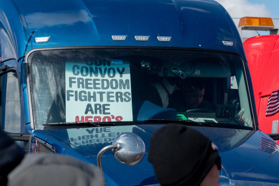 A trucker displays a sign in his cab at the People's Convoy rally, a movement opposing COVID-19 mandates, in Adelanto Stadium in Adelanto on Wednesday, Feb. 23, 2022.