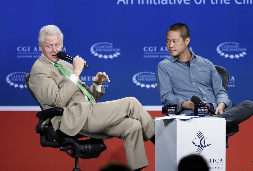 FILE - In this June 25, 2014, file photo, former President Bill Clinton, left, speaks with Zappos.com CEO Tony Hsieh during a forum on the final day of the annual gathering of the Clinton Global Initiative America in Denver. Hsieh, retired CEO Zappos.com, has died. Hsieh was with family when he died Friday, Nov. 27, 2020, according to a statement from DTP Companies, which he founded. Downtown Partnership spokesperson Megan Fazio says Hsieh passed away in Connecticut, KLAS-TV reported. Hsieh recently retired from Zappos after 20 years leading the company. He worked to revitalize the Las Vegas area. (AP Photo/Brennan Linsley, File)