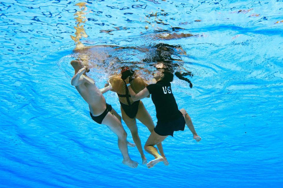 A member of Team USA (R) recovers USA's Anita Alvarez (L), from the bottom of the pool during an incident in the women's solo free artistic swimming finals, during the Budapest 2022 World Aquatics Championships