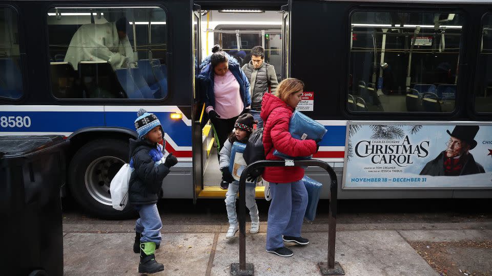 A group of migrants departs a bus at a Chicago police station in November. Migrants are typically transported by city buses after arriving in the city. - Terrence Antonio James/Chicago Tribune/TNS/Getty Images