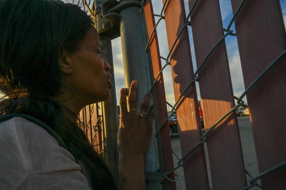 Nicole Casper peers beyond the fence to look for her motor home at Chima’s Tow in Sacramento on Monday after it was towed away during a city homeless sweep. She was trying to recover sentimental belongings, photo albums and her childhood Bible before the motorhome was crushed. “They took my whole life,” she said.