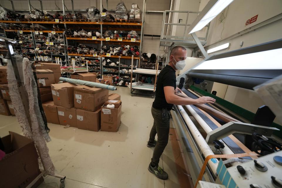 A worker checks the quality of the textiles of the D. Exterior production at the Cose di Maglia factory, in Brescia, Italy, Tuesday, June 14, 2022. Small Italian fashion producers are still allowed to export to Russia, despite sanctions, as long as the wholesale price is under 300 euros. But they are having a hard time getting paid, due to restrictions tied to the financial sector. (AP Photo/Luca Bruno)