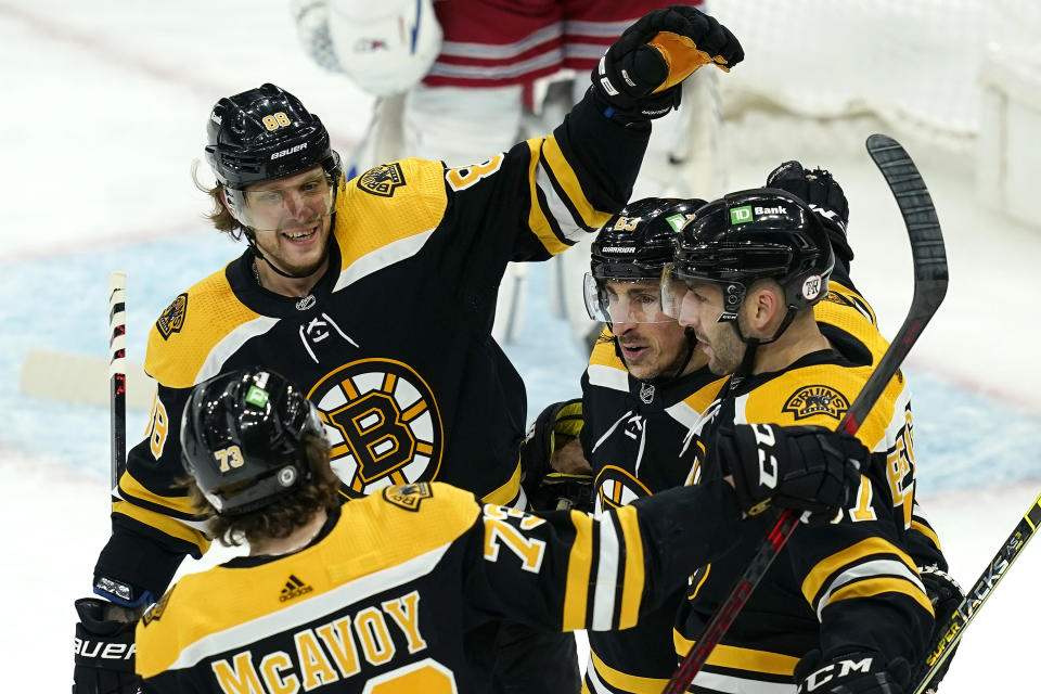 Boston Bruins right wing David Pastrnak (88), defenseman Charlie McAvoy (73), and center Brad Marchand (63) gather to celebrate a goal by center Patrice Bergeron, right, in the first period of an NHL hockey game against the New York Rangers, Thursday, May 6, 2021, in Boston. (AP Photo/Elise Amendola)