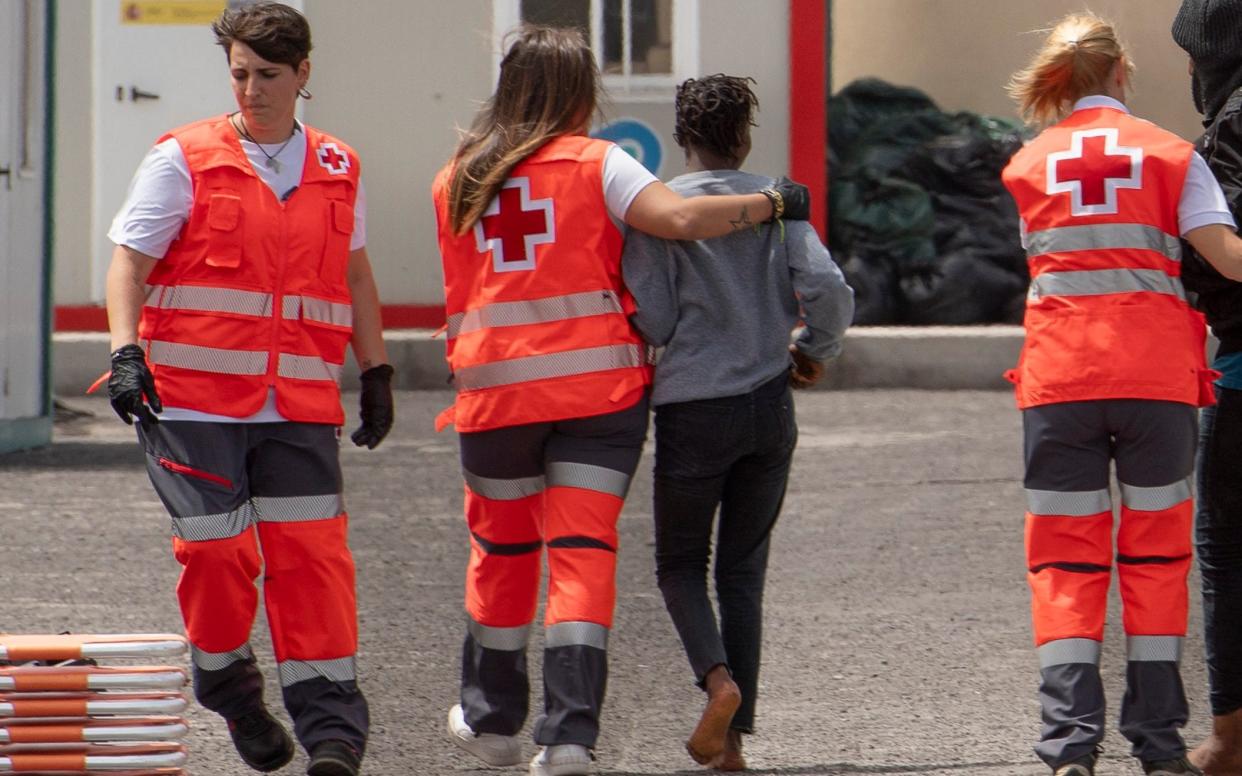 Red Cross workers assist migrants arriving on on the Canary island of El Hierro