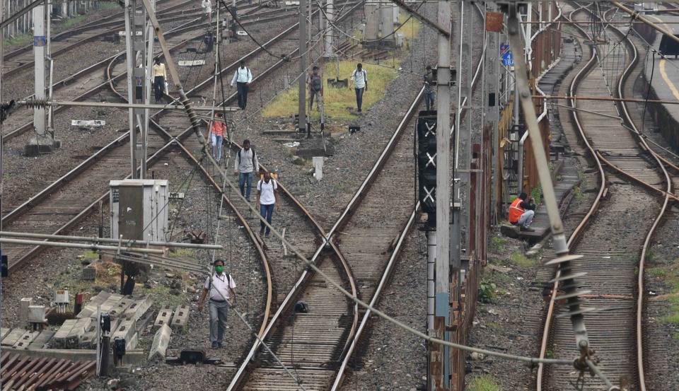 Passengers walk on a railway track after trains got stranded due to a major power cut in Mumbai. (Photo by Arun Patil)