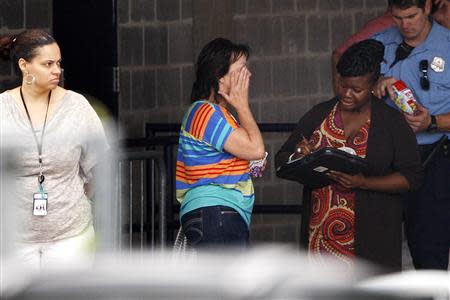 A woman wipes away tears as she arrives at a makeshift shelter for evacuated Navy Yard workers, at Nationals Park baseball stadium near the affected naval installation in Washington, September 16, 2013. REUTERS/Jonathan Ernst