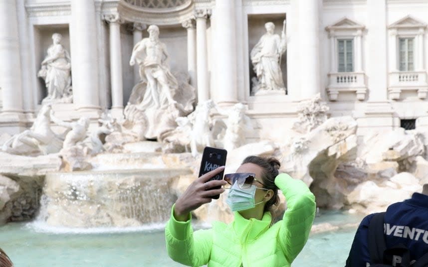 A tourist wearing a face mask at the Trevi Fountain in Rome - Alessia Pierdomenico /BLOOMBERG  