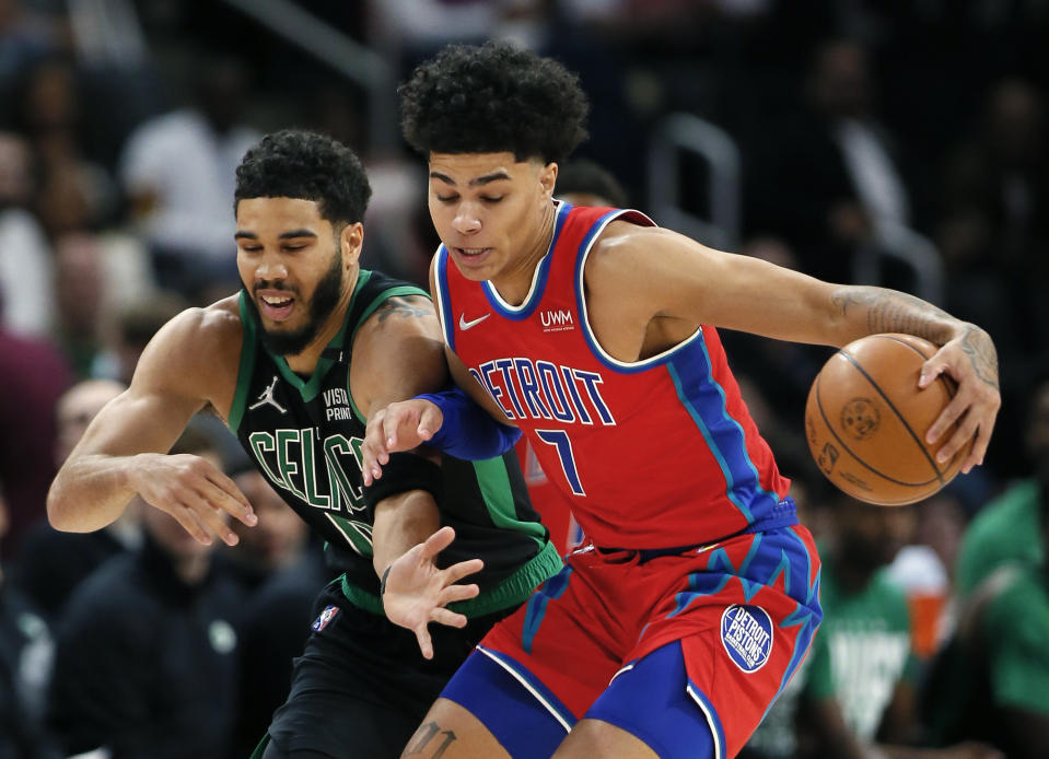 Detroit Pistons guard Killian Hayes (7) manages to keep the ball away from Boston Celtics forward Jayson Tatum (0) during the first half of an NBA basketball game Saturday, Feb. 26, 2022, in Detroit. (AP Photo/Duane Burleson)