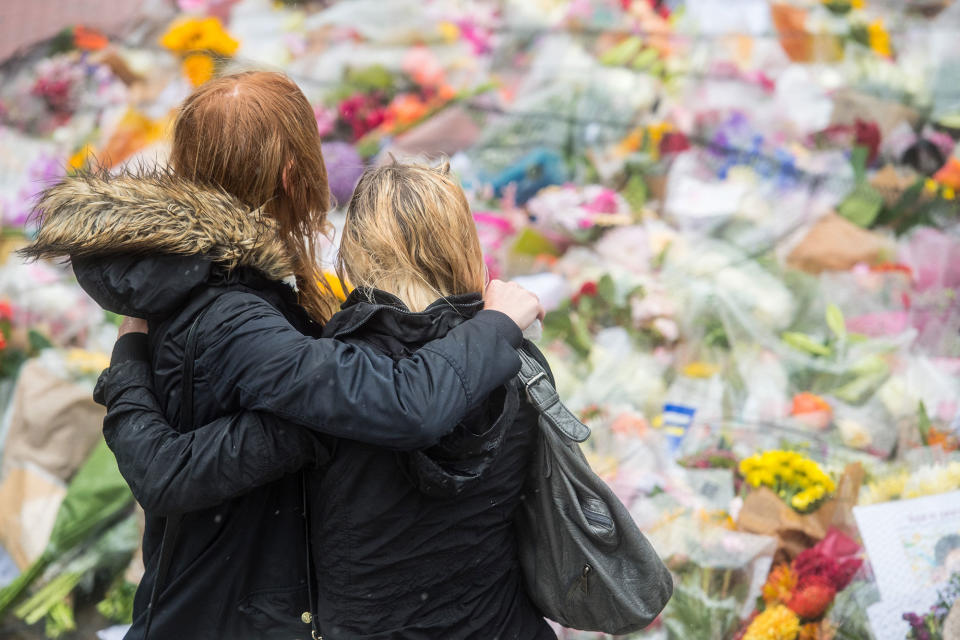 <p>Women comfort each other as they look at flowers laid near the scene of Saturday’s terrorist attack, ahead of a minutes silence, on June 6, 2017 in London, England. (Photo: Carl Court/Getty Images) </p>