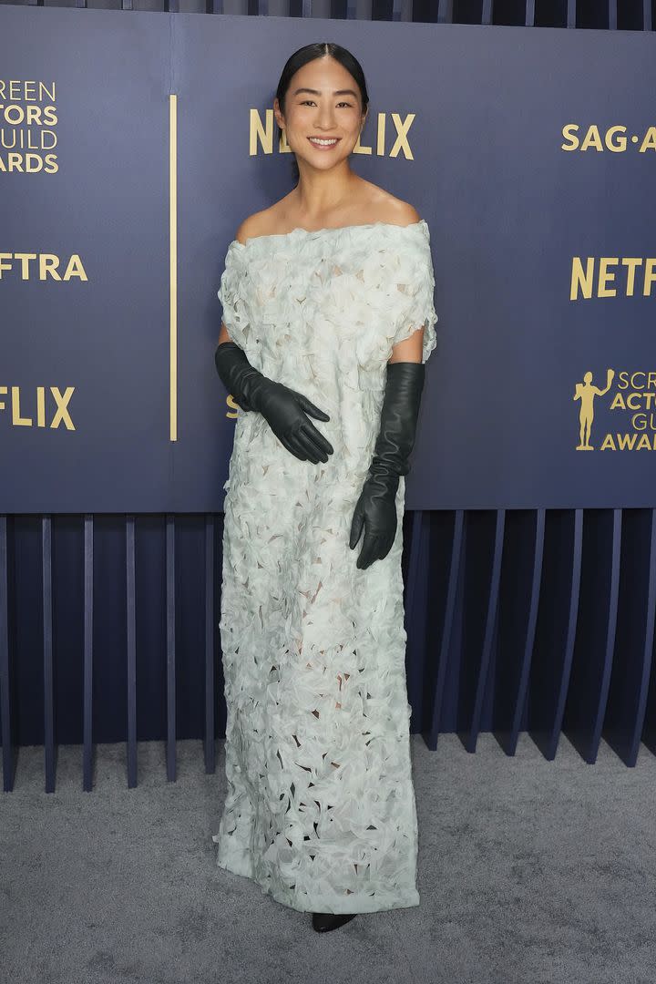 Greta Lee, nominada por su trabajo en The Morning Show, optó por un vestido con textura que combinó con unos guantes negros de cuero