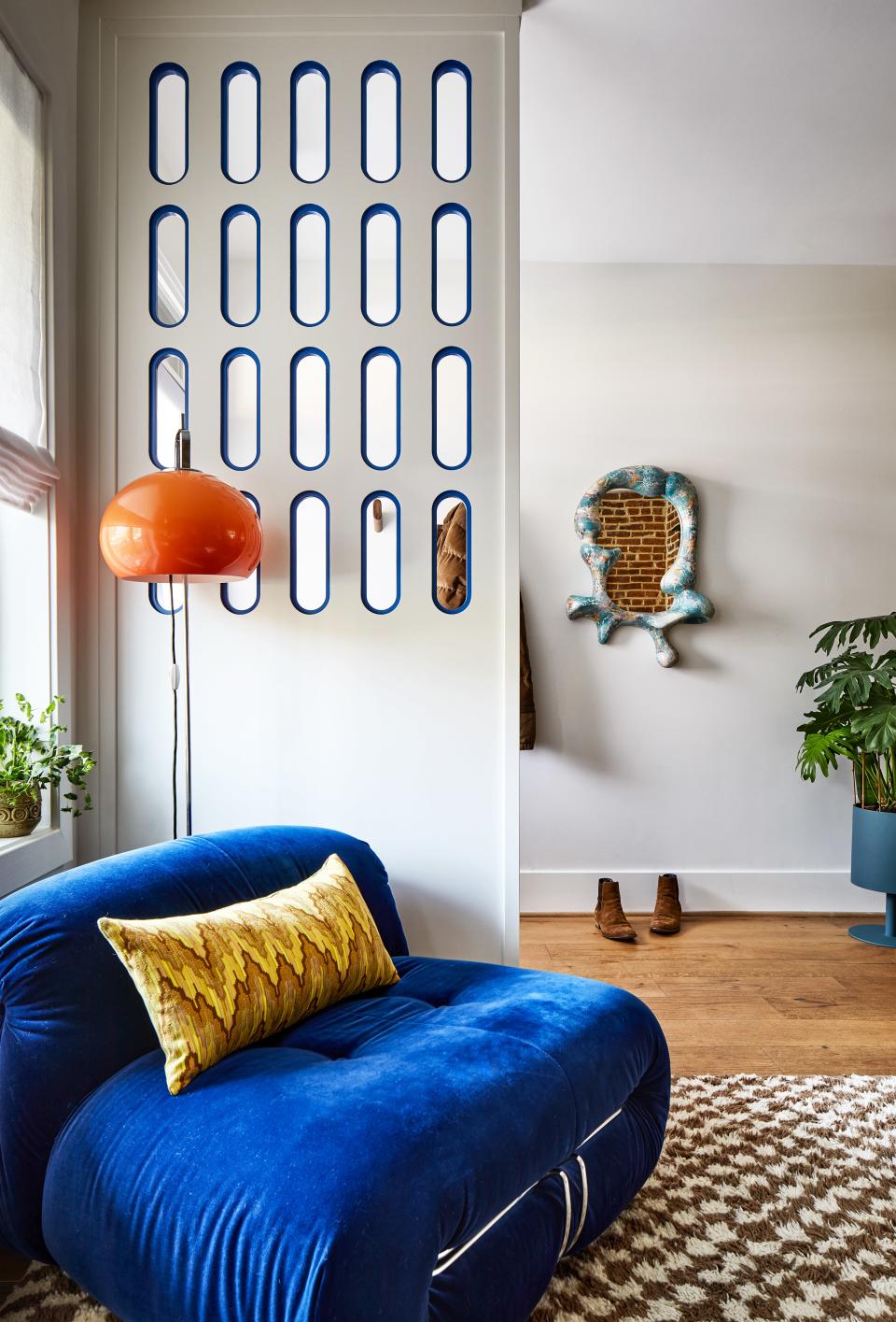 The entryway basks in cool tones, courtesy of a pale blue Iris mirror by Concrete Cat, sourced via Coming Soon, and a cobalt sofa. Zoë counterbalanced the calm with a tangerine lamp from Etsy and a checkered micro rug from June + Blue. Benjamin Moore’s Simply White mutes the walls.