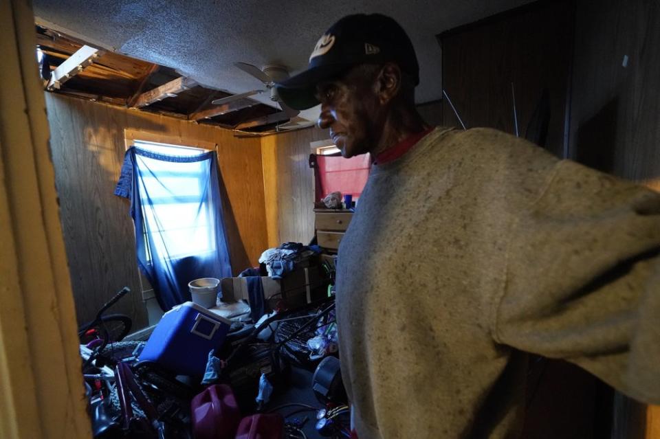 Ernest Jack moves through his home that was hit by Hurricane Laura ahead of Hurricane Delta, Friday, Oct. 9, 2020, in Lake Charles, La. (AP Photo/Gerald Herbert)