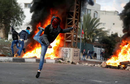 A Palestinian demonstrator hurls stones toward Israeli troops during clashes at a protest against U.S. President Donald Trump's decision to recognize Jerusalem as the capital of Israel, near the West Bank city of Nablus, December 29, 2017. REUTERS/Mohamad Torokman