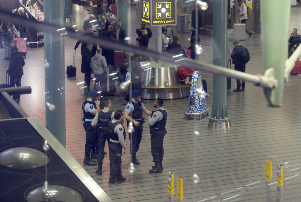 Dutch military police and security officers mill about after a threat at Schiphol airport in Amsterdam, Netherlands, Wednesday, Nov. 6, 2019. Dutch military police say that all passengers and crew are safely off a plane at the center of a security alert at Amsterdam's Schiphol Airport. The military police service earlier said they were responding to a suspicious situation at the airport on the outskirts of Amsterdam. (AP Photo/Peter Dejong)