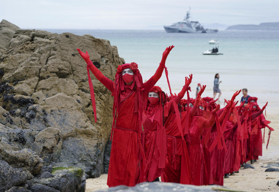 Protestors in costumes march on the beach of Carbis Bay outside the G7 meeting taking place in St. Ives, Cornwall, England, Friday, June 11, 2021. Leaders of the G7 begin their first of three days of meetings on Friday in Carbis Bay, in which they will discuss COVID-19, climate, foreign policy and the economy. (AP Photo/Jon Super)